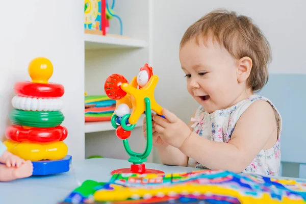 Девочка играет с развивающей игрушкой в детской — стоковое фото