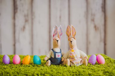 Paskalya yumurtaları ile çimlerde oturan tavşan