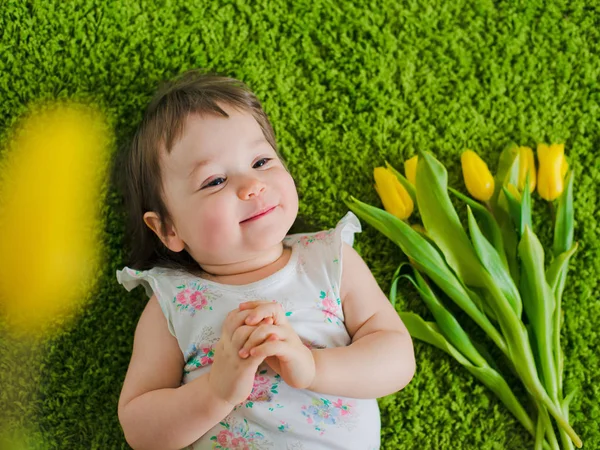 The child lies on the grass with flowers — Stock Photo, Image