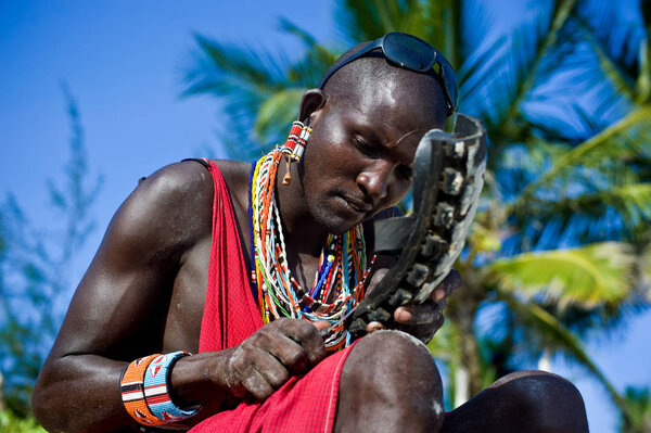 A man of the Maasai tribe makes shoes out of an automobile tire