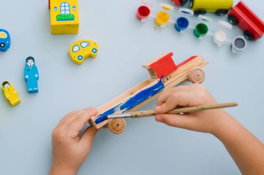 Bir çocuğun elleri ahşap bir makine boya
