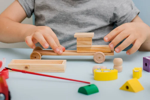 The child glues wooden model car — Stock Photo, Image