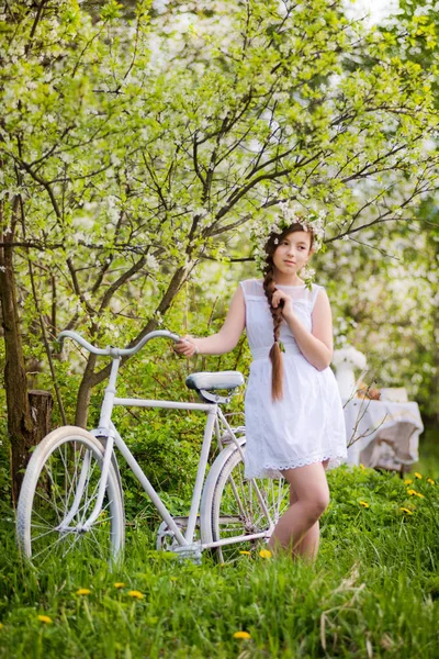 Girl with the bike and a wreath on her head — Stock Photo, Image