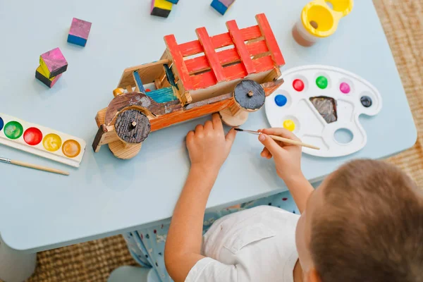 Enfant peint une machine à écrire en bois — Photo