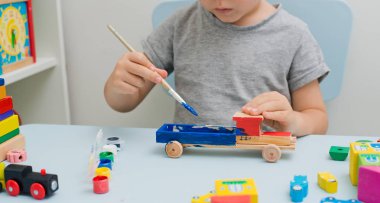 Bir çocuğun elleri ahşap bir makine boya