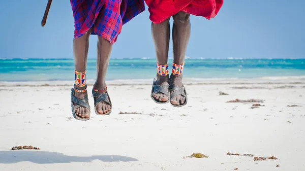 腿男子跳马赛部落的鞋汽车轮胎在海洋的背景下 — 图库照片