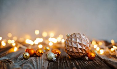 Noel ağacı topu oyuncağı, tahta bir masanın üzerinde tatil ışıklarına karşı duruyordu..