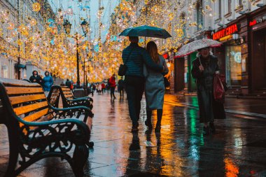 Büyük bir şehirde yağmurlu bir gece. Islak yol yüzeyindeki ışıkların yansımaları..
