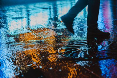 Büyük bir şehirde yağmurlu bir gece. Islak yol yüzeyindeki ışıkların yansımaları..