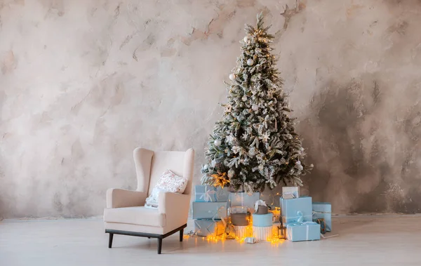 Árvore decorada de Natal com presentes e cadeira no fundo da parede na sala de estar. — Fotografia de Stock