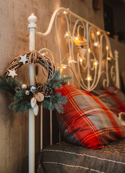 Grinalda de Natal pendurada na cabeceira decorada com luzes guirlanda bokeh. — Fotografia de Stock