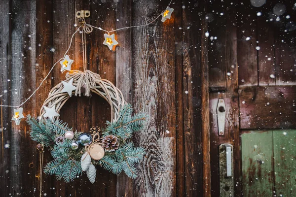 蓝树的乡村木门背景上的圣诞花环. 图库图片