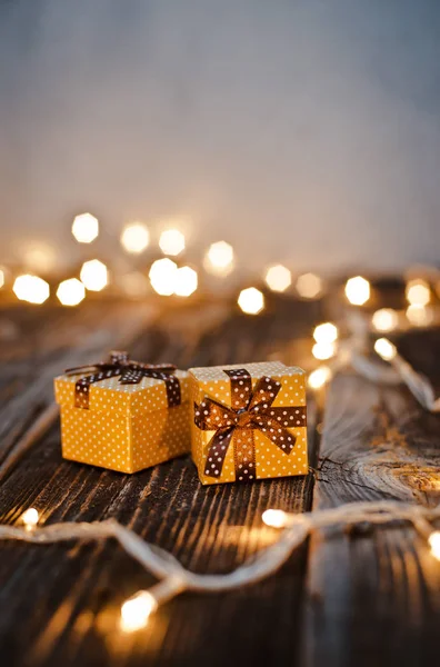 Caixa de presente de Natal colocar em uma mesa de madeira em um fundo bokeh de luzes festivas. — Fotografia de Stock