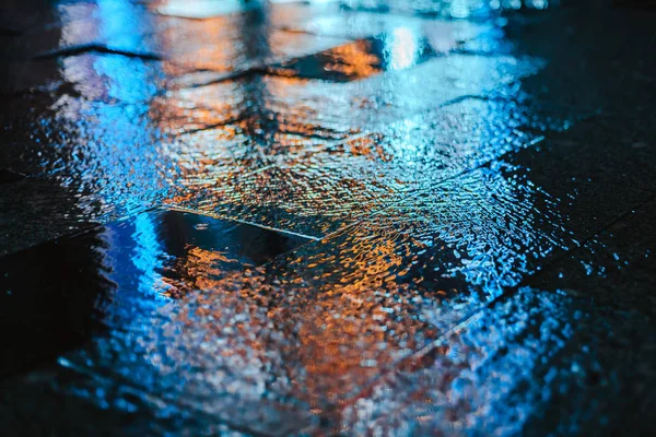 Rainy night in a big city, reflections of lights on the wet road surface. — Stock Photo, Image