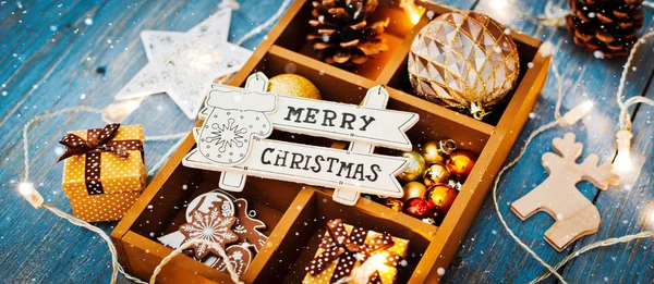 Dekoracje świąteczne są w pudełku na niebieskim drewnianym tle. — Zdjęcie stockowe