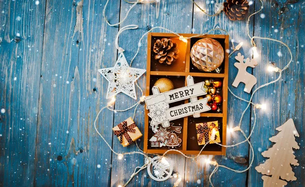 Christmas decorations are in a box on a blue wooden background. — Stock Photo, Image