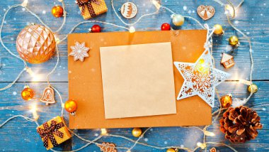 Yeni yıl dekorasyonları, mavi ahşap arka plandaki çelenkleri yakmak için boş bir yer..