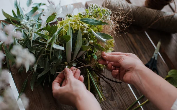 Florista profesional femenina prepara el arreglo de flores silvestres. — Foto de Stock