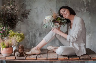 Profesyonel kadın çiçekçi yabani çiçeklerin aranjmanını hazırlıyor..