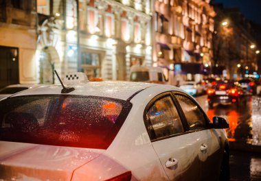 Islak şehir sokağı yağmuru Bokeh 'in yansıması parlak renkli ışıklar kaldırımda su birikintileri ıslak asfalt yol trafiği, trafik, taksi, Rusya' ya ulaşım 05 Kasım 2019.