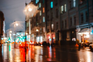 Islak şehir sokağı yağmuru Bokeh yansıması parlak renkli ışıklar kaldırım ışıkları araba farları yansıması ıslak asfalt yol odaklanmış seçici odak bulanık arka plan kırmızı ışık