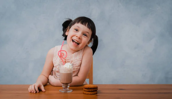 Küçük Bir Kız Sıcak Çikolata Çikolatalı Kurabiye Yer Masadaki Gri — Stok fotoğraf