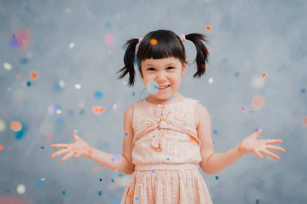 Little Girl Child Cheerfully Throws Colorful Tinsel Confetti Gray Blue — Stock Photo, Image