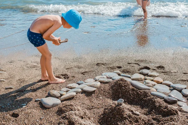 Маленький Хлопчик Грає Пляжі Біля Моря Піску Каменях Побудувати Піщані — стокове фото