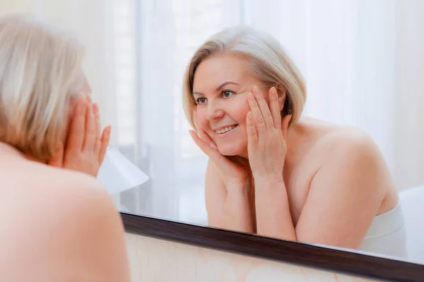 Portret Mooie Oudere Vrouw Met Handen Haar Gezicht Spiegel Thuis — Stockfoto