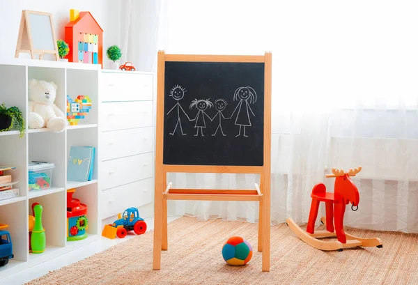 白人孩子们玩五彩缤纷的玩具的房间 幼儿幼稚园游戏场地 室内儿童空间 自由空间 背景图黑板与绘图粉笔族 — 图库照片