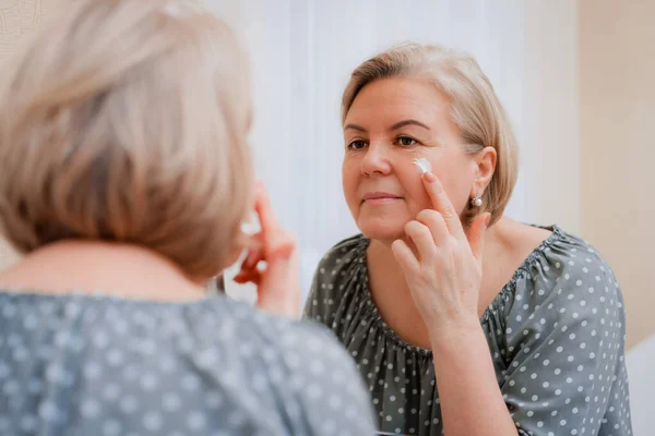 Felice Donna Matura Sana Specchio Applicare Crema Cosmetica Idratante Invecchiamento Fotografia Stock