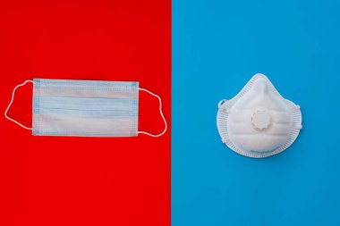Mavi arka planda beyaz bir tıbbi maske ve solunum cihazı. Yüz maskesi çevre kirliliğine, grip virüslerine ve koronavirüse karşı korur. Sağlık ve Cerrahi Konsept.