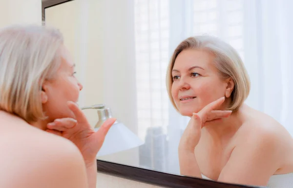 Portret Mooie Oudere Vrouw Met Handen Haar Gezicht Spiegel Thuis — Stockfoto