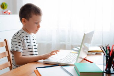 Uzaktan öğrenme çevrimiçi eğitim. Bir okul çocuğu evde ders çalışır ve okul ödevi yapar. Evden öğrenme.