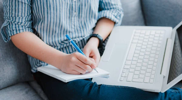 student studying home working with her laptop doing homework close up sofa. Concept distance learning education during quarantine covid-19 coronavirus, remote education, e-learning, stay home safe