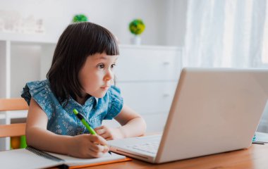 Uzaktan öğrenme çevrimiçi eğitim. Evde bir kız bebek ve ev ödevi yapıyor. Evden öğrenme.