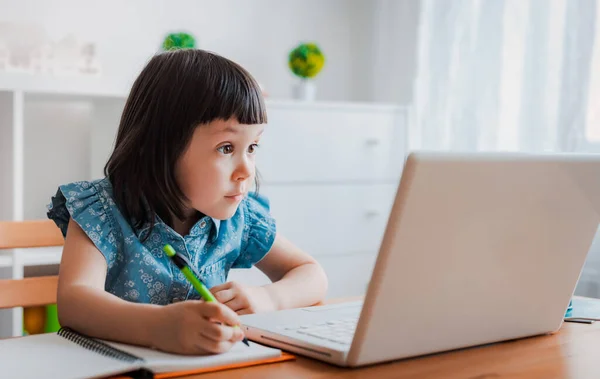 远程在线教育 一个小女孩在家里做作业 家庭远程学习 图库照片