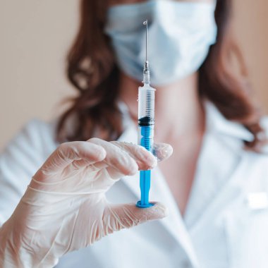 Doktorun eline şırınga enjekte edip yakın çekim yapın. İğne düşüşlü aşı için tıbbi plastik ekipman..