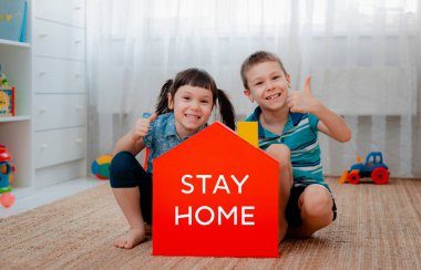 Çocuklar erkek ve kız elleri kırmızı modelle birlikte notlarla evde kalsın. Koronavirüs salgınını önleme ve koruma. Virüsü durdur. Evde karantina, kendini izole etme.