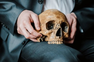 Kafatası, koyu renk takım elbiseli bir adamın elinde, osteopatik bir doktorun.