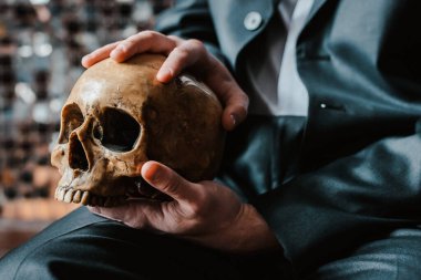 Kafatası, koyu renk takım elbiseli bir adamın elinde, osteopatik bir doktorun.