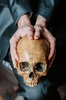 Kafatası, koyu renk takım elbiseli bir adamın elinde, osteopatik bir doktorun.