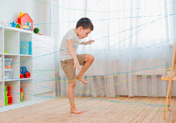 Irmão menino, irmãos, amigoscriança sobe através de uma teia de corda, uma busca obstáculo jogo dentro de casa . — Fotografia de Stock