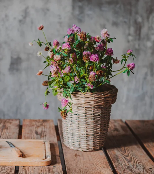 Hermosos ramos de flores silvestres sobre una mesa de madera sobre un fondo de pared de hormigón frío . — Foto de Stock