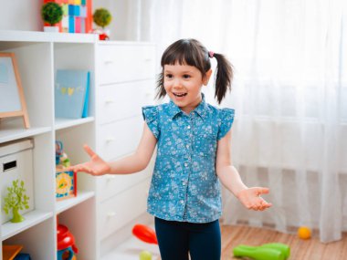 Çocuklar oyun odasında top oynayan küçük bir kız çocuğu. etkileşim konsepti ebeveyn ve çocuk, iletişim, karşılıklı oyun, karantina, kişisel izolasyon evi, eğitim.