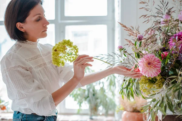 Kvinnlig Professionell Florist Förbereder Arrangemanget Vilda Blommor Blomsteraffär Bakgrund Betong — Stockfoto