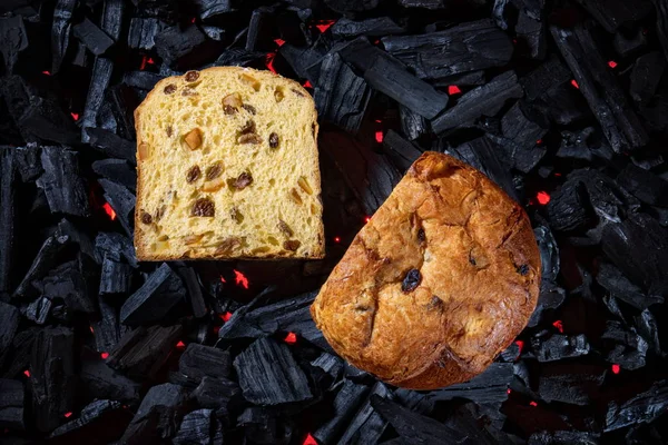 Panettone placed on black charcoal with red fire background — Stock Photo, Image