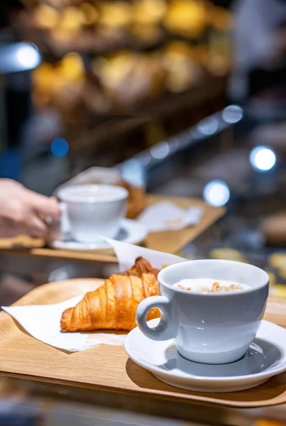 Koffie en croissant geserveerd in een banketbakkerij wazig achtergrond — Stockfoto