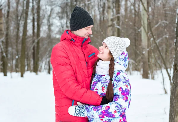Paar camera kijken met een glimlach in winter park — Stockfoto