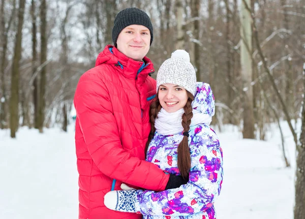 Paar camera kijken met een glimlach in winter park — Stockfoto